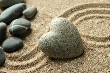 Gri zen stone kum arka plan üzerinde kalp şeklinde