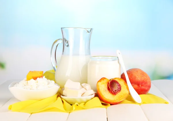 Fresh dairy products with peaches on wooden table on natural background — Stock Photo, Image