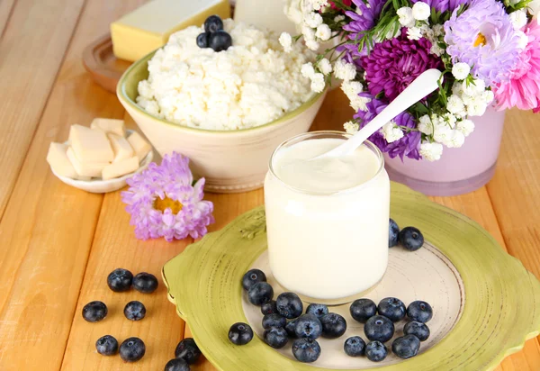 Verse zuivelproducten met bosbessen op houten tafel close-up — Stockfoto