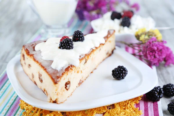 Cheese casserole with raisins on plate on napkin on wooden table close-up — Stock Photo, Image