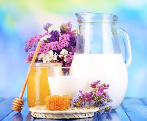 Honning og melk på trebord på blå bakgrunn – stockfoto
