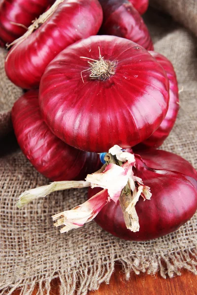 Cebollas rojas frescas en arpillera —  Fotos de Stock