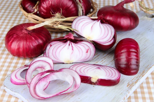 Oignons rouges frais sur planche à découper fermer — Photo