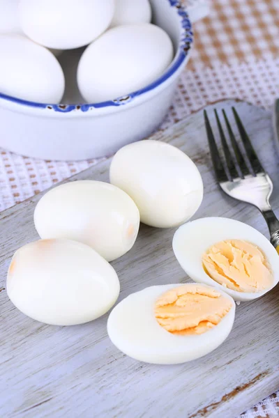 Ovos cozidos em tábua de madeira na toalha de mesa — Fotografia de Stock