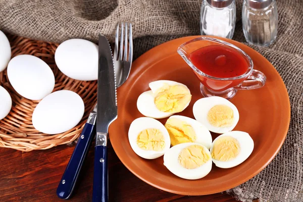 Huevos cocidos en plato sobre tabla de madera sobre mantel sobre mesa de madera —  Fotos de Stock