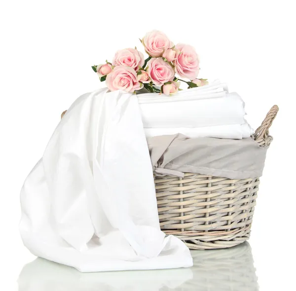 Bedding sheets in wicker basket isolated on white — Stock Photo, Image