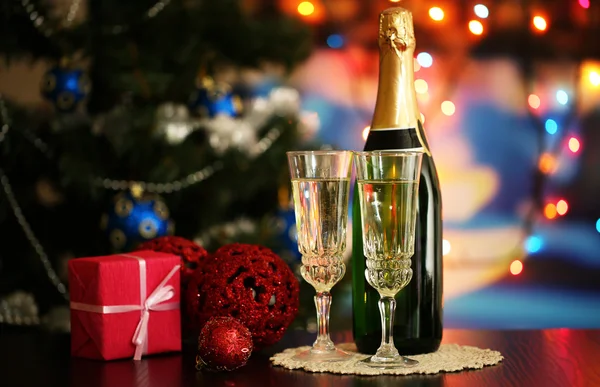 Glasses of champagne and gift on bright background — Stock Photo, Image