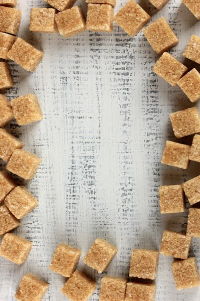 Hnědý cukr na dřevěné pozadí — Stock fotografie