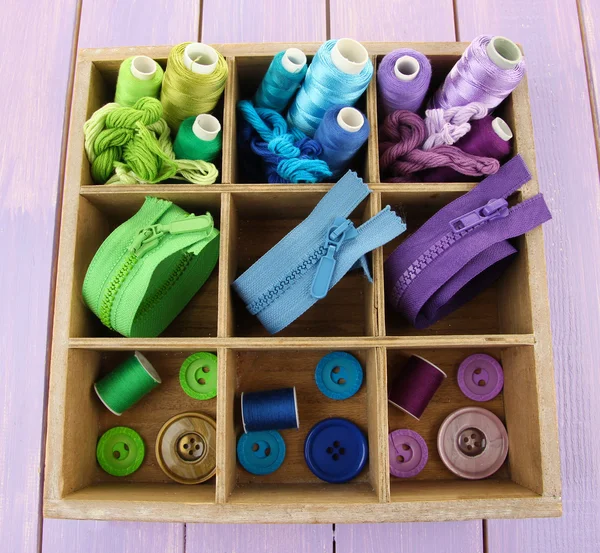 Multicolored skeins of thread with fasteners and buttons in box closeup — Stock Photo, Image