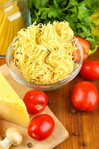 Pasta with oil, cheese and vegetables on wooden table close-up — Stock Photo, Image