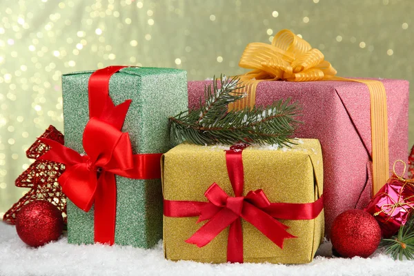 Hermosos regalos brillantes y decoración de Navidad, sobre un fondo brillante — Foto de Stock