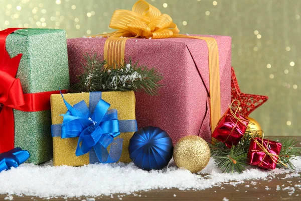 Schöne helle Geschenke und Weihnachtsdekoration, auf glänzendem Hintergrund — Stockfoto