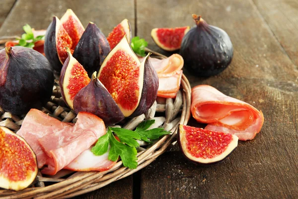 Fichi saporiti con prosciutto sul tavolo di legno grigio — Foto Stock