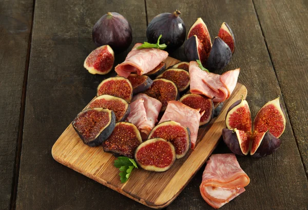 Smakelijke vijgen met ham op grijze houten tafel — Stockfoto