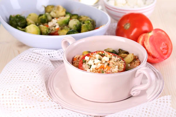 Gefüllte Tomaten in Pfanne und Schüssel auf Holztisch in Großaufnahme — Stockfoto