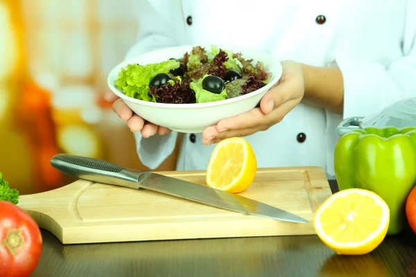 Cocine las manos sosteniendo el plato de ensalada — Foto de Stock
