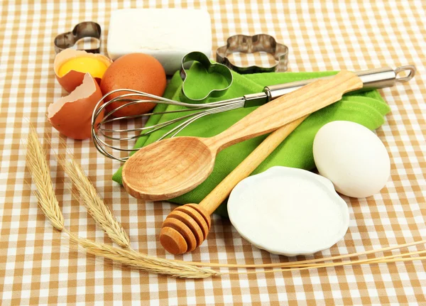 Conceito de cozinha. Ingredientes básicos de cozimento e ferramentas de cozinha em fundo de toalha de mesa — Fotografia de Stock