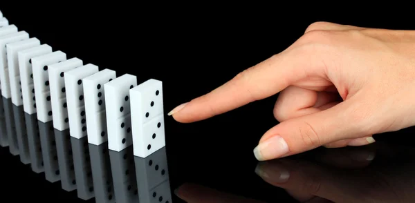 Mano spingendo domino isolato su nero — Foto Stock