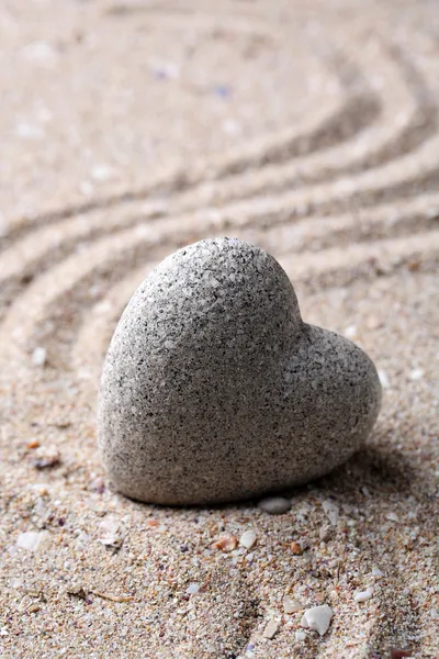 Pedra zen cinza em forma de coração, sobre fundo de areia — Fotografia de Stock