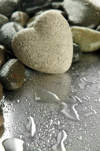 Grey stone in shape of heart, on light background — Stock Photo, Image