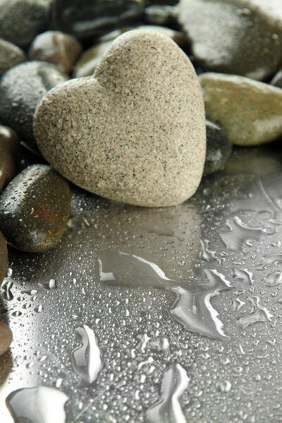 Grey stone in shape of heart, on light background