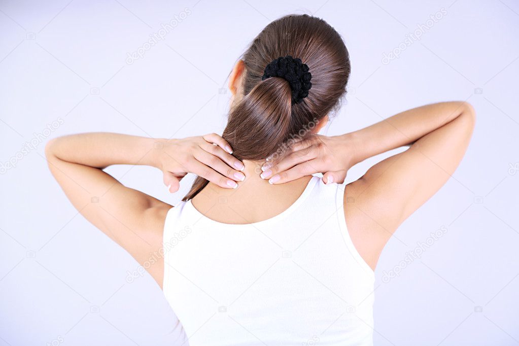 Young girl and pain in neck gray background
