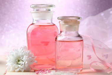 pembe bir arka plan üzerinde renkli özü ile cam şişe