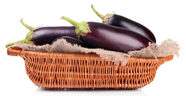 Verse aubergines in rieten mand geïsoleerd op wit — Stockfoto