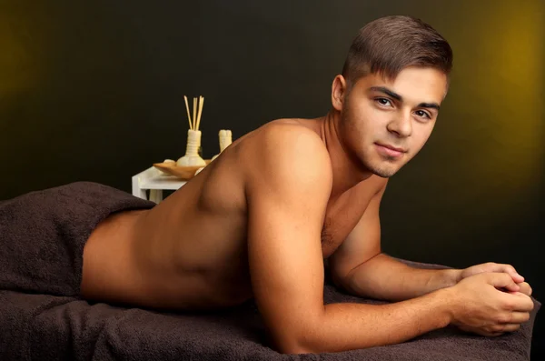 Giovane uomo rilassato nel salone spa — Foto Stock