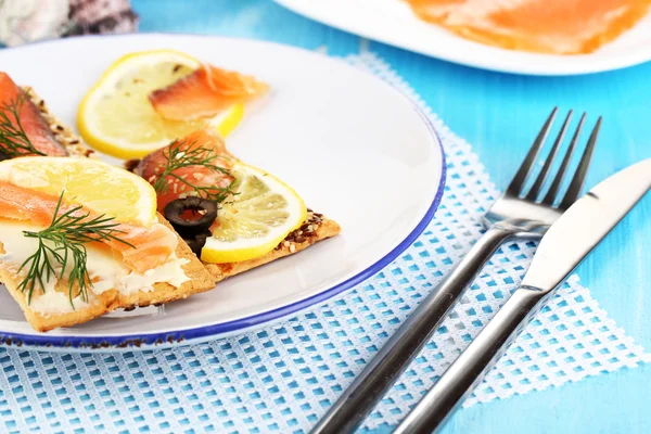 Salmon sandwiches on plate on wooden table close-up — Stock Photo, Image