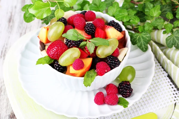 Ensalada de frutas en tazón, sobre fondo de mesa de madera —  Fotos de Stock