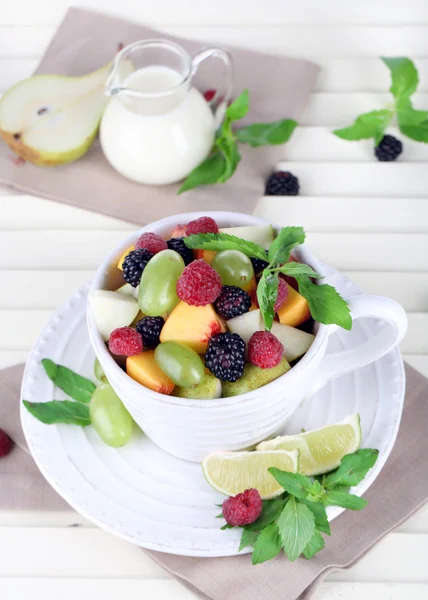 Salade de fruits en tasse sur table en bois — Photo