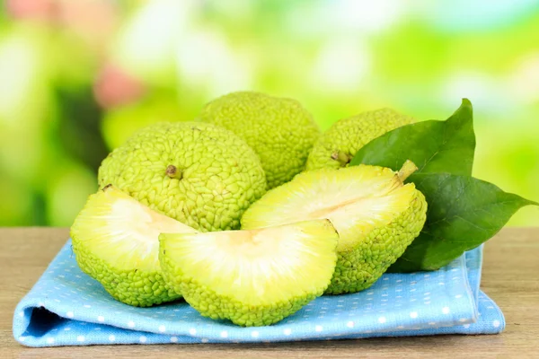 Osage orange frukter (maclura pomifera) i korg, på träbord, på natur bakgrund — Stockfoto