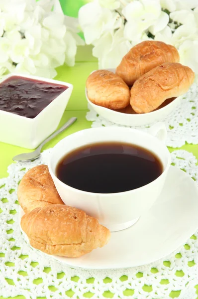 Tasty croissants and cup of coffee on table close-up — Stock Photo, Image