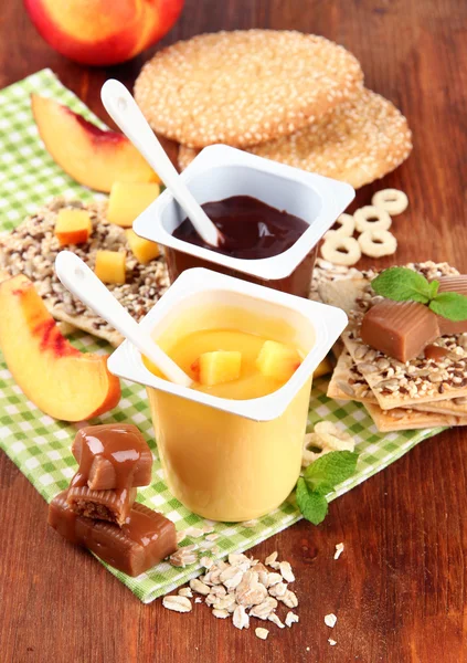 Adet taze meyve, kurabiye ve renk ahşap zemin üzerinde pul ile krem lezzetli tatlılar — Stok fotoğraf