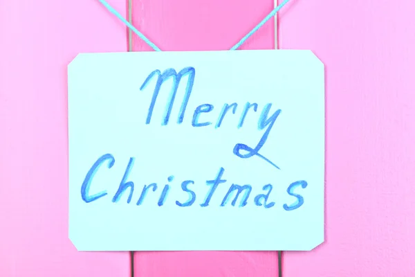 Panneau avec des mots Joyeux Noël sur fond de table en bois rose close-up — Photo