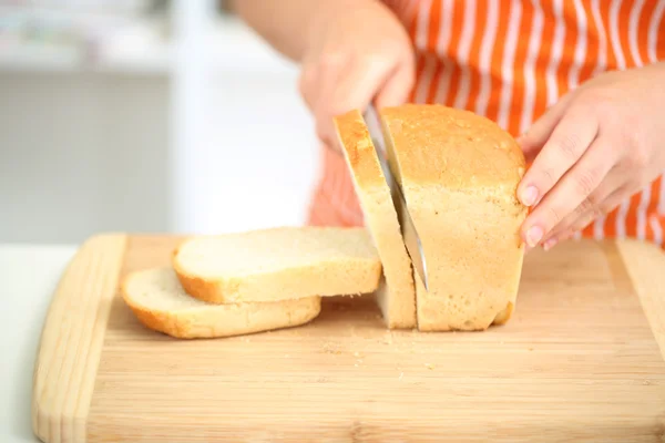 Donna affettare il pane sul tagliere, da vicino — Foto Stock