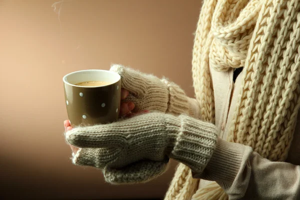 Mani femminili con bevanda calda, su sfondo a colori — Foto Stock