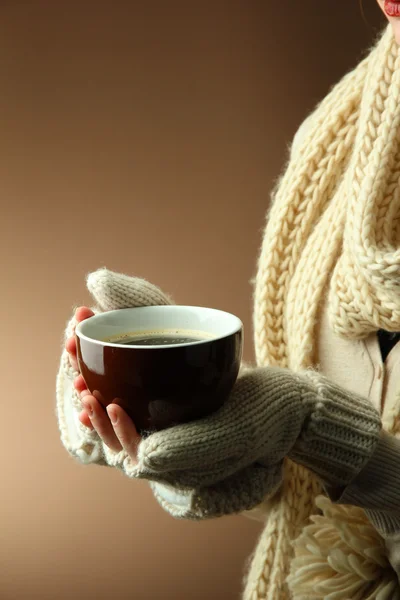 Female hands with hot drink, on color background — Stock Photo, Image