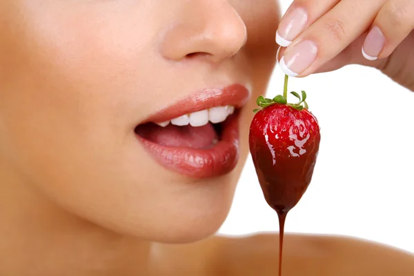 Primer plano de la mujer comiendo fresa en chocolate — Foto de Stock