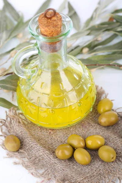 Olive oil and branch on sackcloth close up — Stock Photo, Image