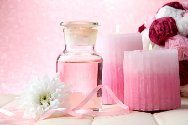 Botella de vidrio con esencia de color, sobre fondo rosa — Foto de Stock