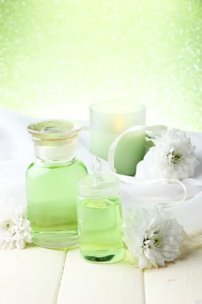 Glass bottles with color essence, on wooden table, on green background — Stock Photo, Image