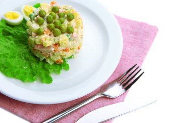 geleneksel Rus salatası olivier renkli peçete üzerinde beyaz tabakta üzerine beyaz izole.