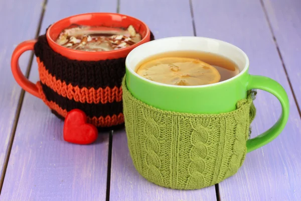 Tazas con cosas de punto en ella en la mesa de madera de cerca —  Fotos de Stock