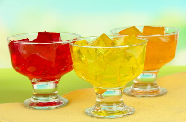 Tasty jelly cubes in bowls on table on light background — Stock Photo, Image
