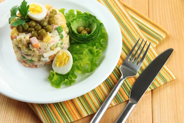 Salada tradicional russa Olivier, em guardanapo de cor, em fundo de madeira — Fotografia de Stock