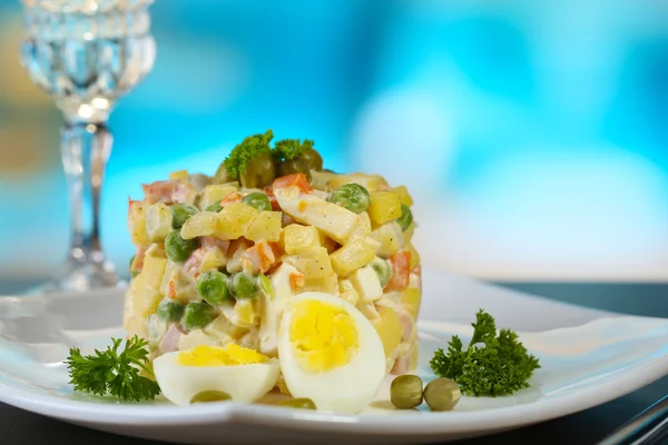 Salada tradicional russa Olivier, no guardanapo a cores, na mesa de madeira, no fundo brilhante — Fotografia de Stock