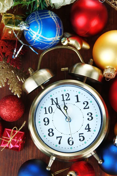 Reloj despertador con decoraciones navideñas sobre fondo de madera — Foto de Stock