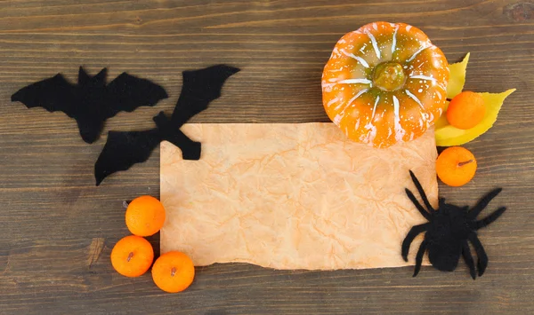 Old paper with Halloween decorations on grey wooden background — Stock Photo, Image